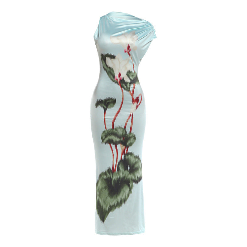 Light blue sheath summer dress with one-shoulder drape and green floral print, studio