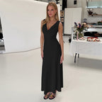 Black sleeveless midi dress with V-neck, fitted bodice, and flowing skirt
