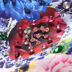 Floral sequin embellishment detail with pink, blue, and crystal-like stones on white fabric