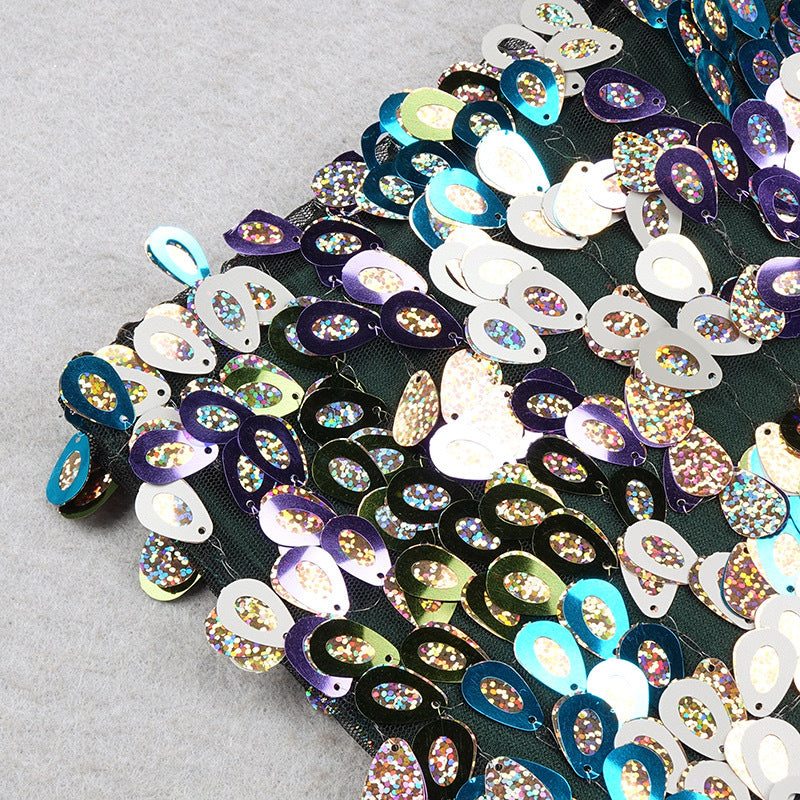 Close-up of multicolor sequins on dark fabric with pink feather trim edge