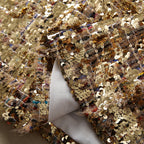 Gold sequin fabric with dense sparkle and colorful reflections on sheer underlayer