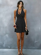 Black halter V-neck mini dress with white polka dots, front view
