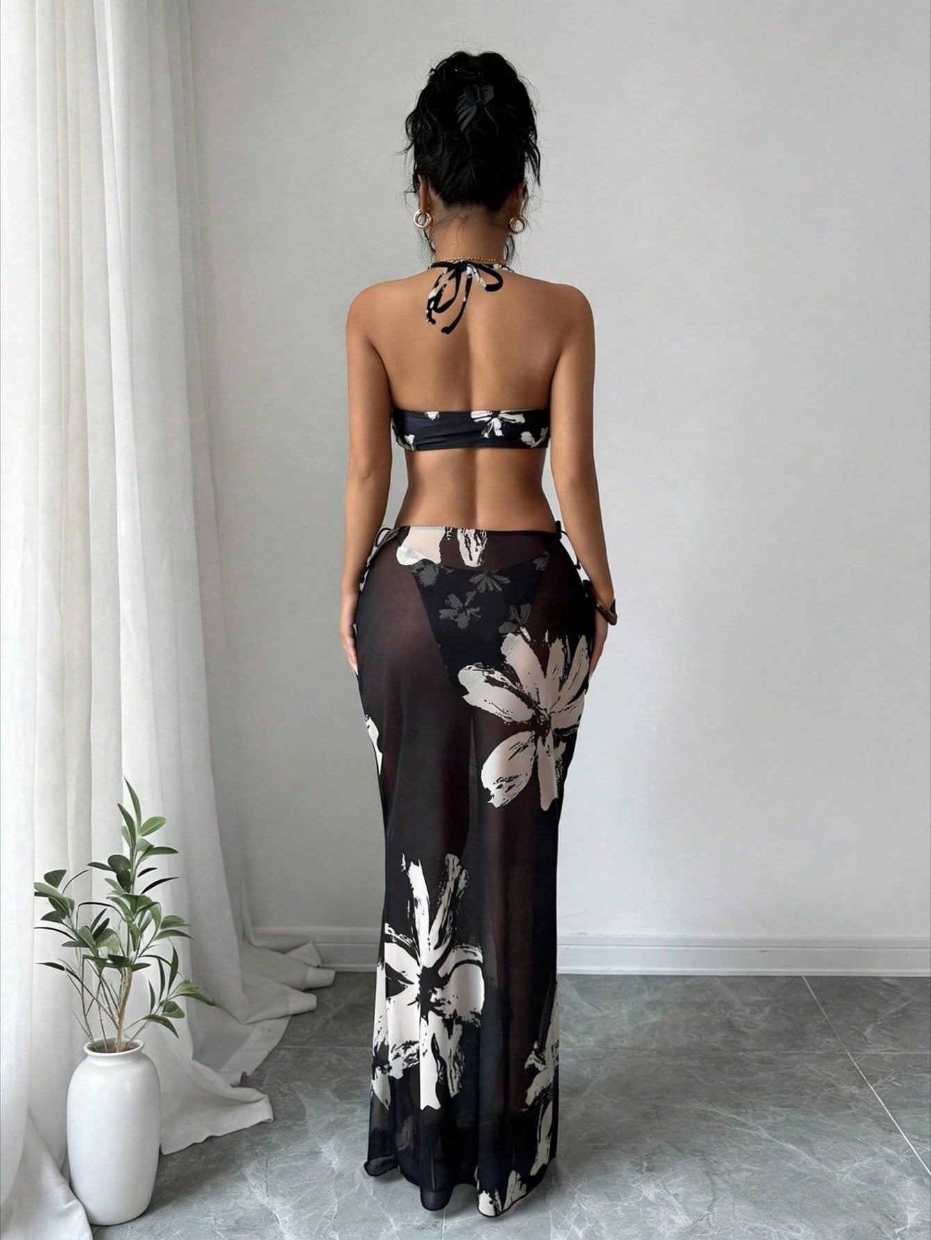 Back of black halter bikini with white floral print and matching long skirt
