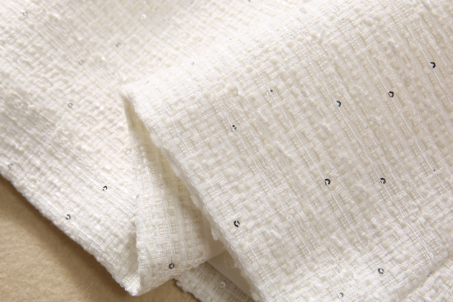 Beige woven fabric with scattered tiny dark sequins