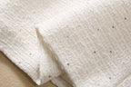 Beige woven fabric with scattered tiny dark sequins