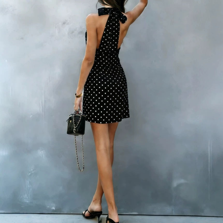 Black halter V-neck mini dress with white polka dots, side view