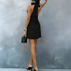 Black halter V-neck mini dress with white polka dots, side view